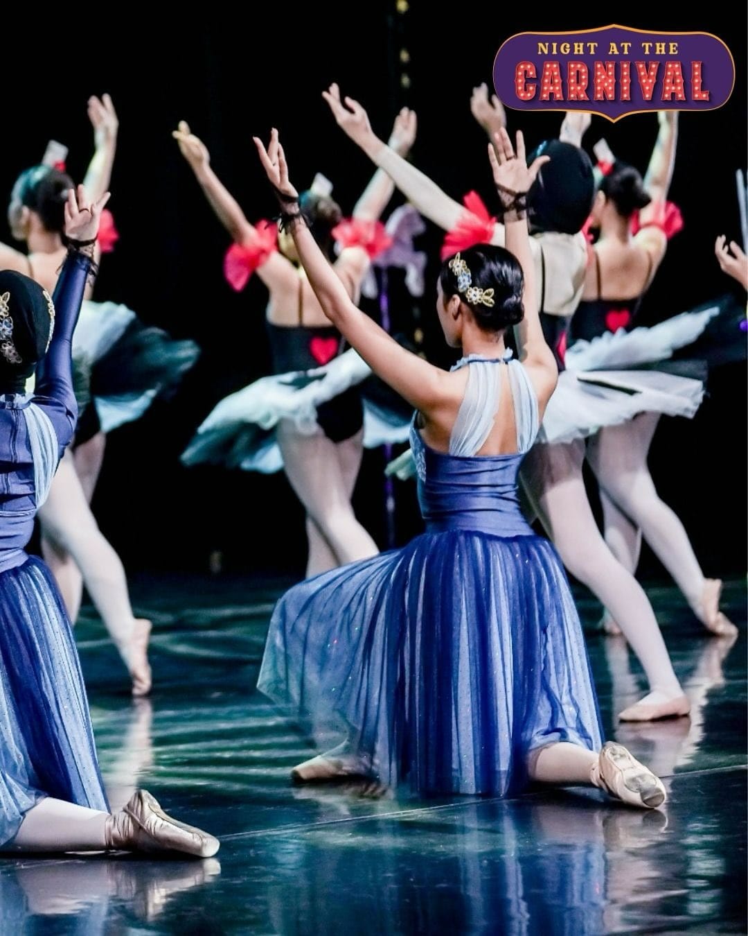 Ballerinas in blue tutus kneeling on stage