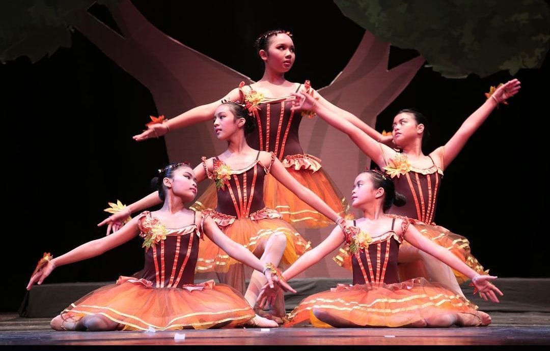 Princessa dancers in autumn leaf costumes striking a pose on stage